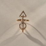 Gold ring with a unique design on a beige fabric background